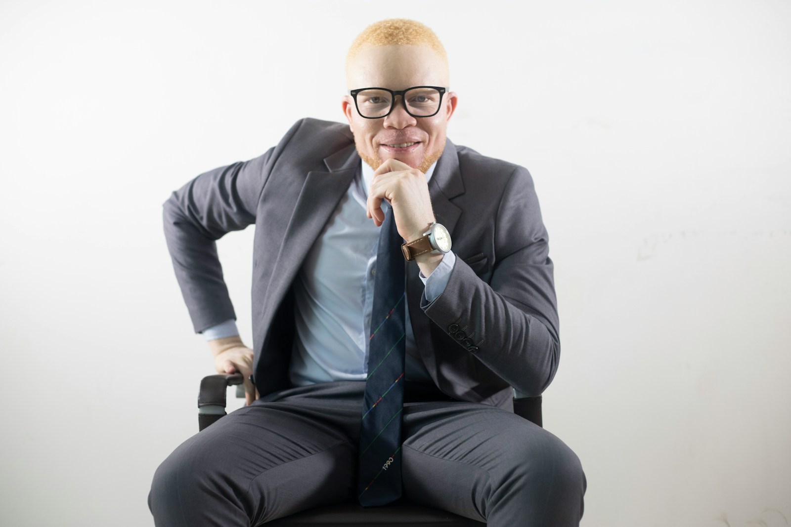 insurance agent man in black suit jacket and black pants sitting on chair